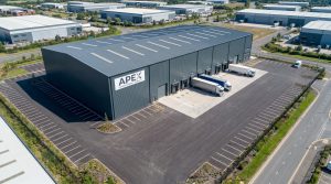 Aerial view of a 20,000 square foot warehouse with loading docks, trucks, and surrounding industrial park.
