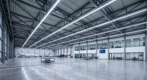 "Spacious aircraft maintenance hangar with clear-span steel structure, housing multiple private jets and helicopters, featuring large windows and polished concrete floors."