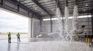 Hangar ceiling with fire suppression foam being deployed, illustrating safety and emergency preparedness.
