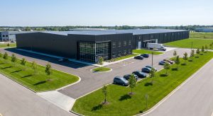 "Aerial view of completed 100 000 Square Foot Building with parking and landscaped grounds"