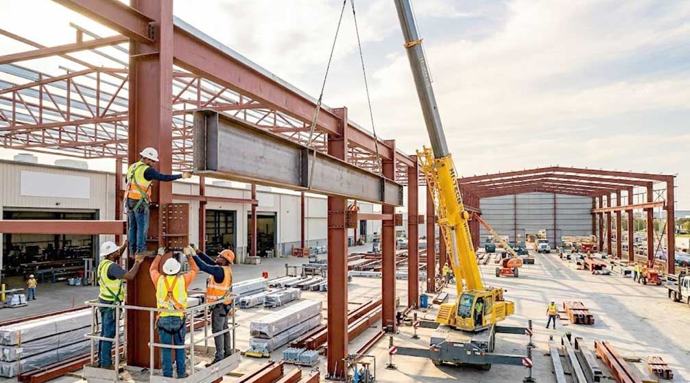 Aircraft hangar steel structure being extended with new columns and roof frames for future facility expansion.