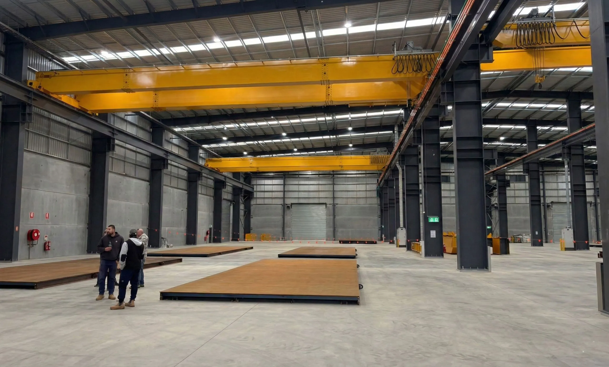 Interior of an Australian concrete panel factory workshop with steel columns and 25T overhead bridge cranes.
