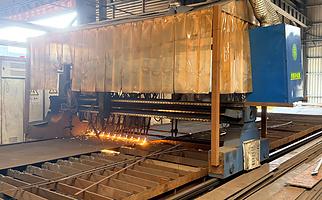 CNC plasma cutting steel plate in the Showhoo fabrication workshop during the controlled cutting process.