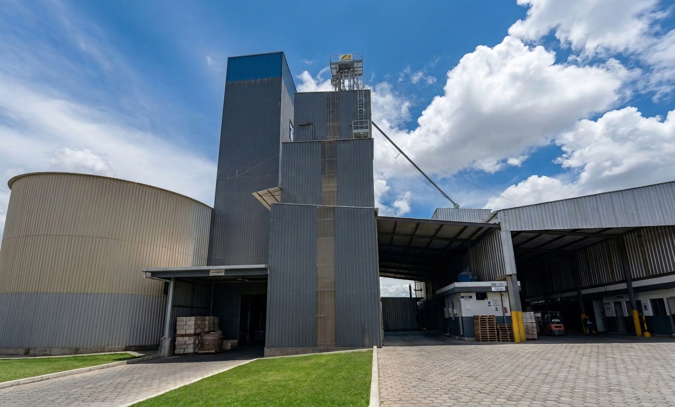 Completed Ecuador feed mill with a 28 m steel processing tower, metal cladding, storage silo and covered loading bays.