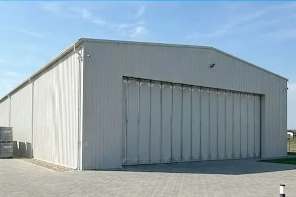 Europe steel aircraft hangar project with large sliding hangar door, metal wall panels, and prefabricated steel frame structure.