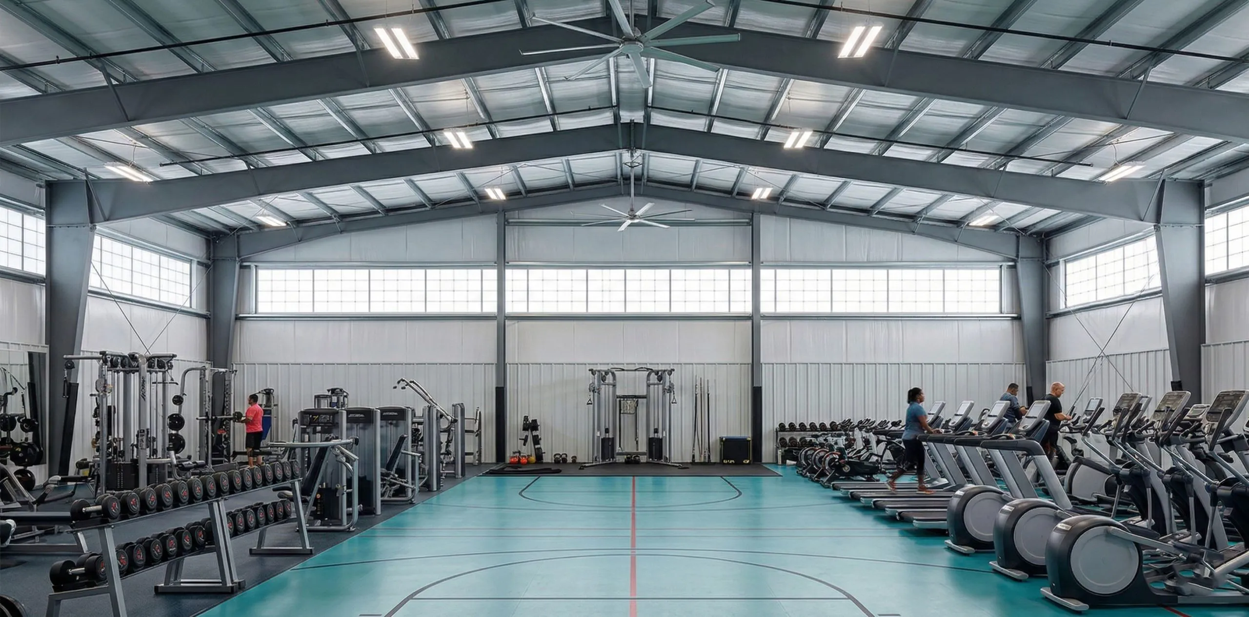 Steel-framed gym interior with a central court, cardio machines, free weights and perimeter training zones