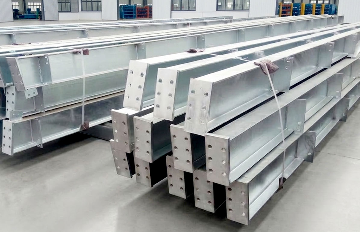 Hot-dip galvanized H-section steel members with drilled end plates and welded brackets stacked for structural assembly.
