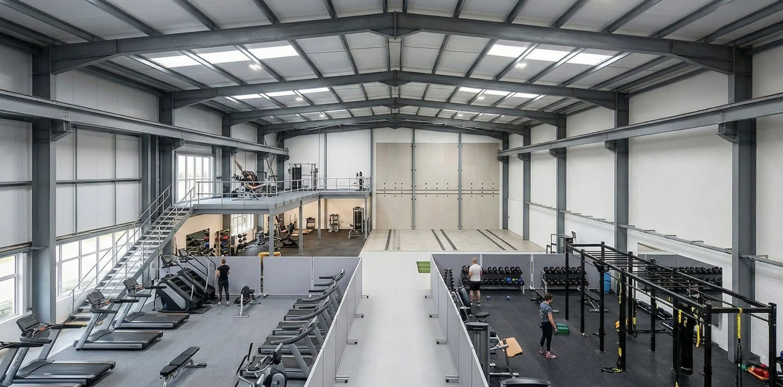 Expansive fitness interior showing treadmills, strength stations, a mezzanine and open floor area for future changes.