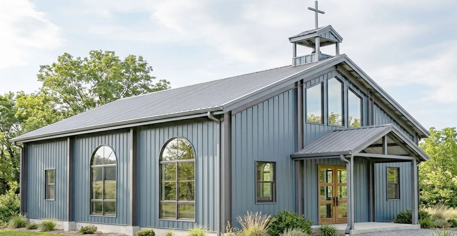 Steel church building designs featuring gray metal wall panels, arched side windows, covered front entrance, and cross-topped cupola for worship projects.