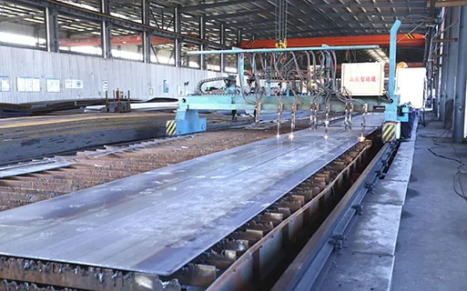 CNC cutting equipment processing steel plates for steel structure fabrication, supporting accurate component production for prefabricated building projects.
