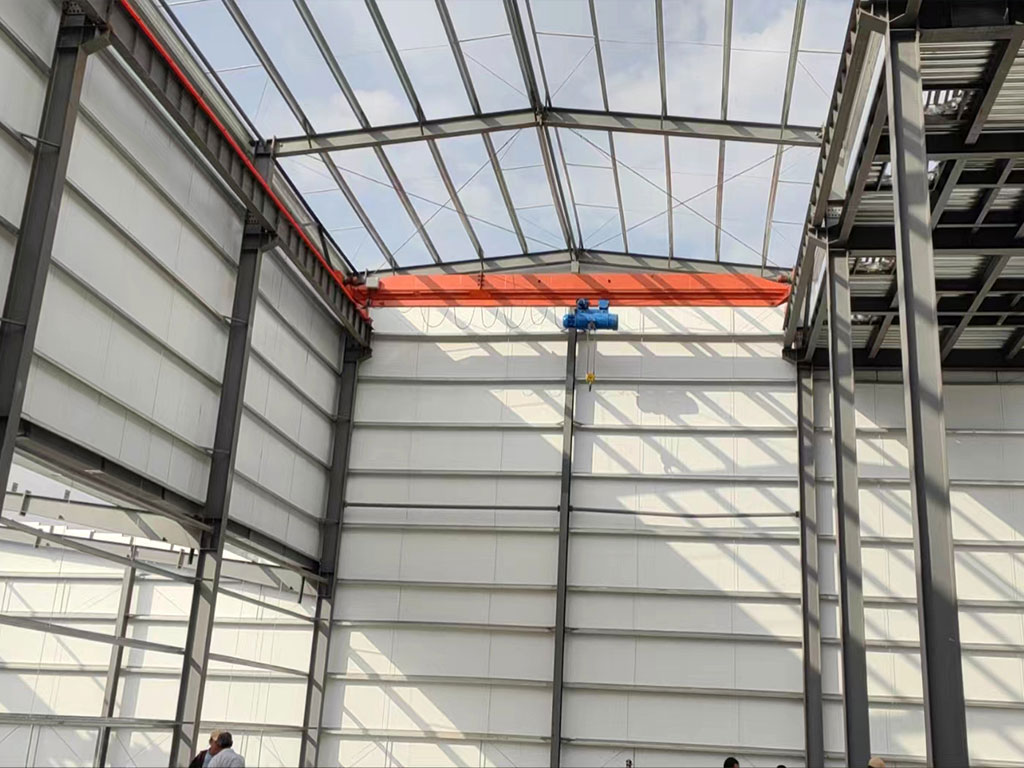Steel structure building project in Uzbekistan with an overhead crane, roof purlins, wall panels, and an internal steel platform.