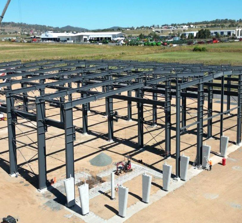 Steel structure warehouse project in Australia showing erected steel columns, beams, roof framing, and bracing during installation.