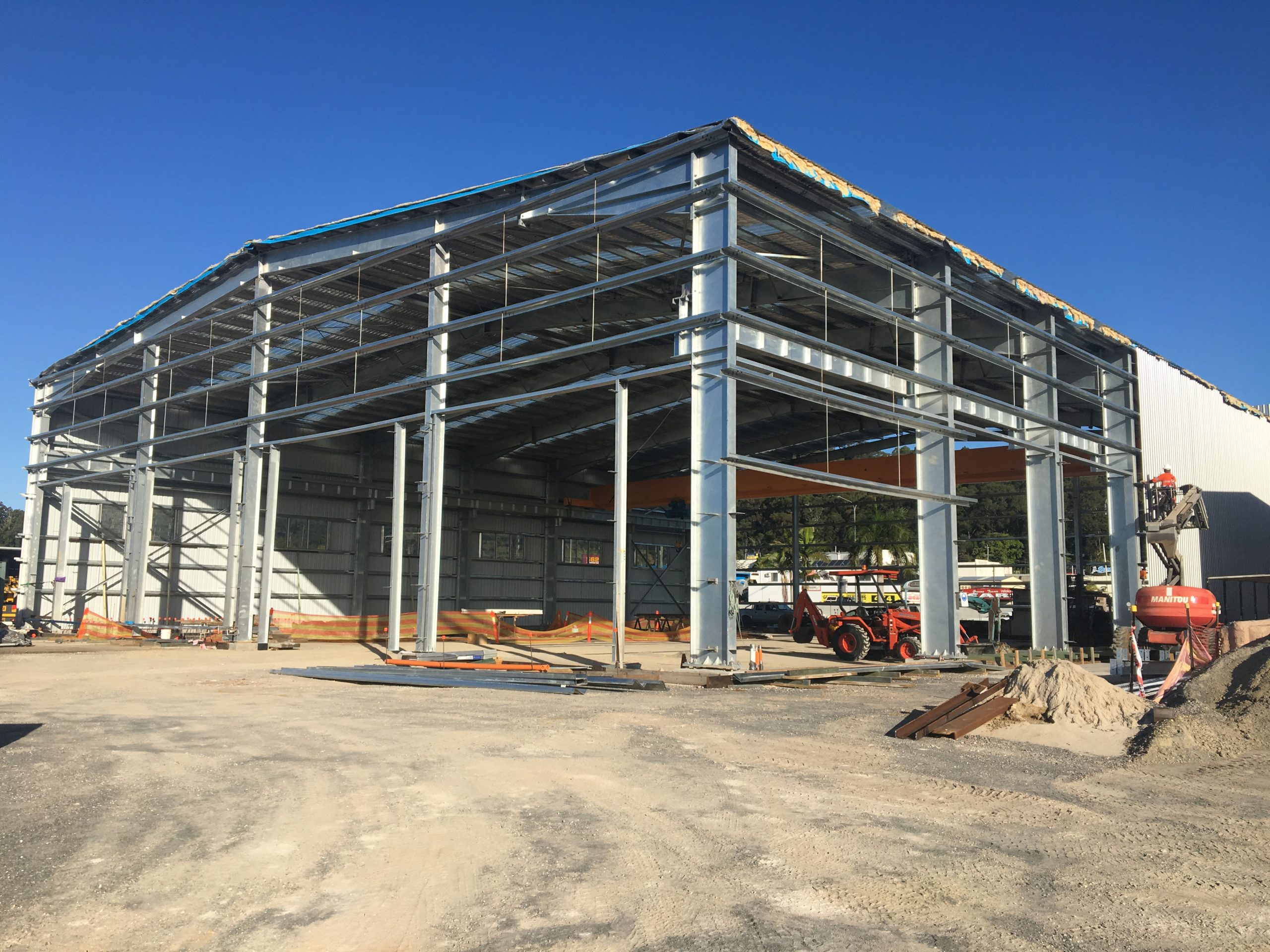 Steel structure workshop project in Australia with galvanized framing, wall girts, roof cladding, and an overhead crane under installation.