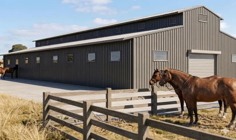 Completed steel horse stable in Uruguay with metal cladding, ventilation openings and fenced paddocks.