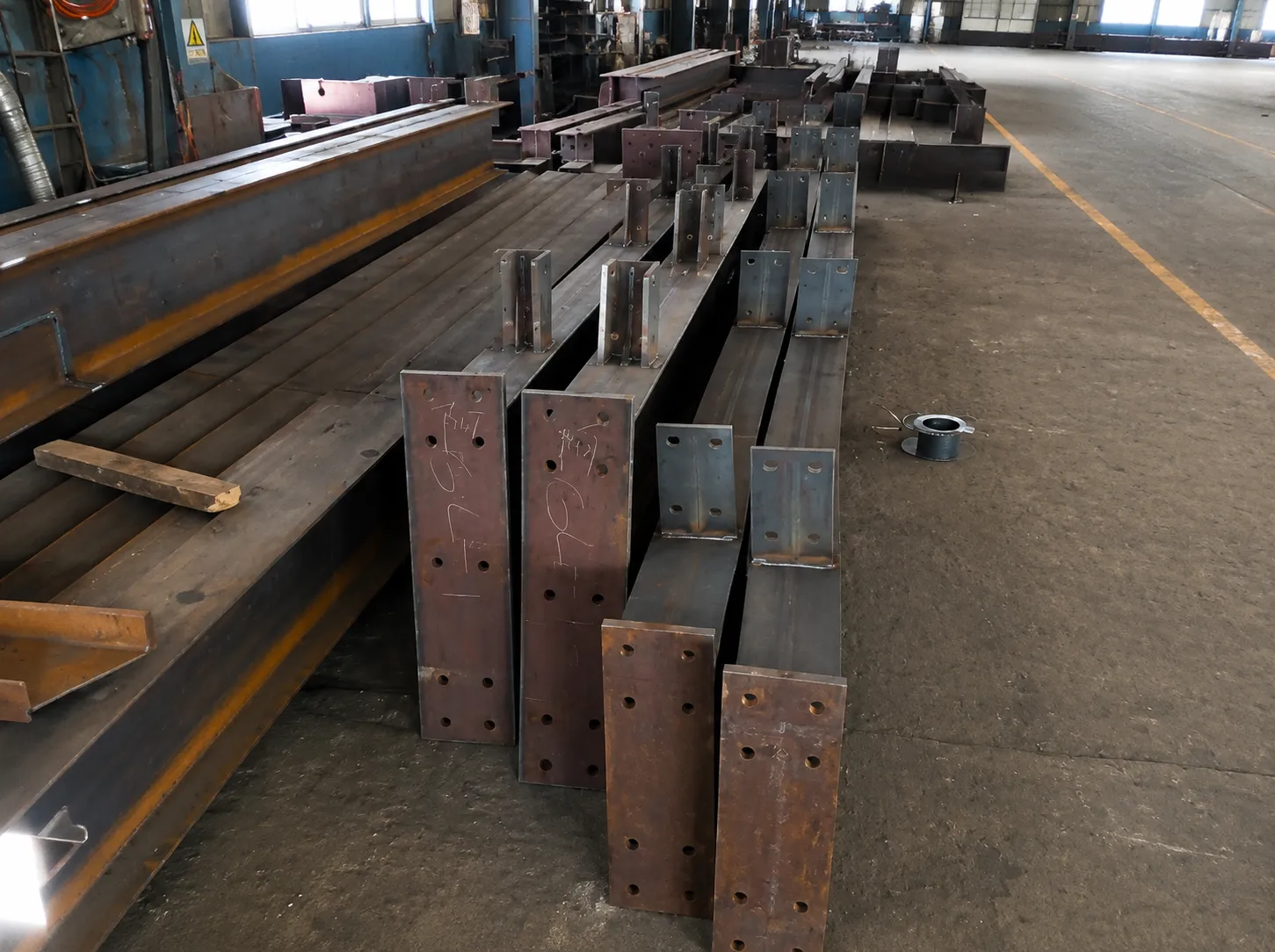 Structural steel beams with welded connection plates fabricated for the 4,320 m² Bolivia warehouse project.