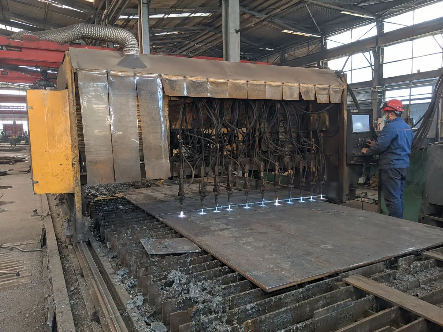 CNC oxy fuel cutting machine processing steel plates in a steel fabrication factory