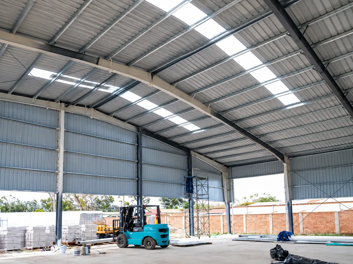 Interior view of Ecuador steel structure warehouse with skylight roof panels and forklift during installation