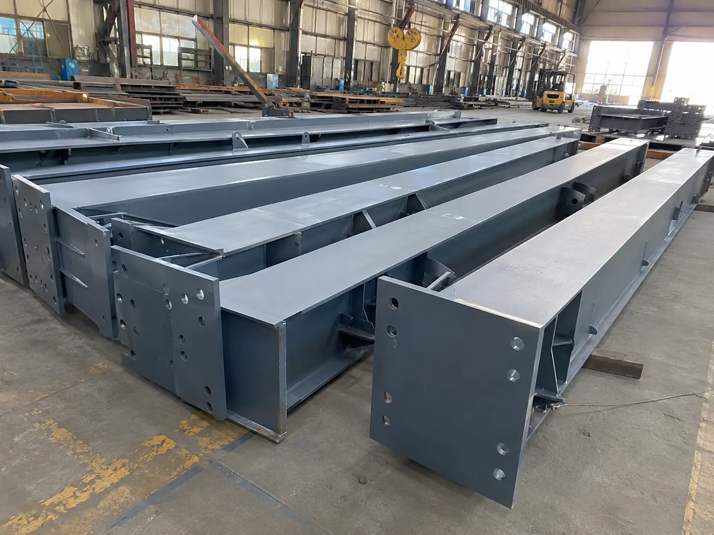 Finished H-section steel components with end plates and connection holes prepared for warehouse installation