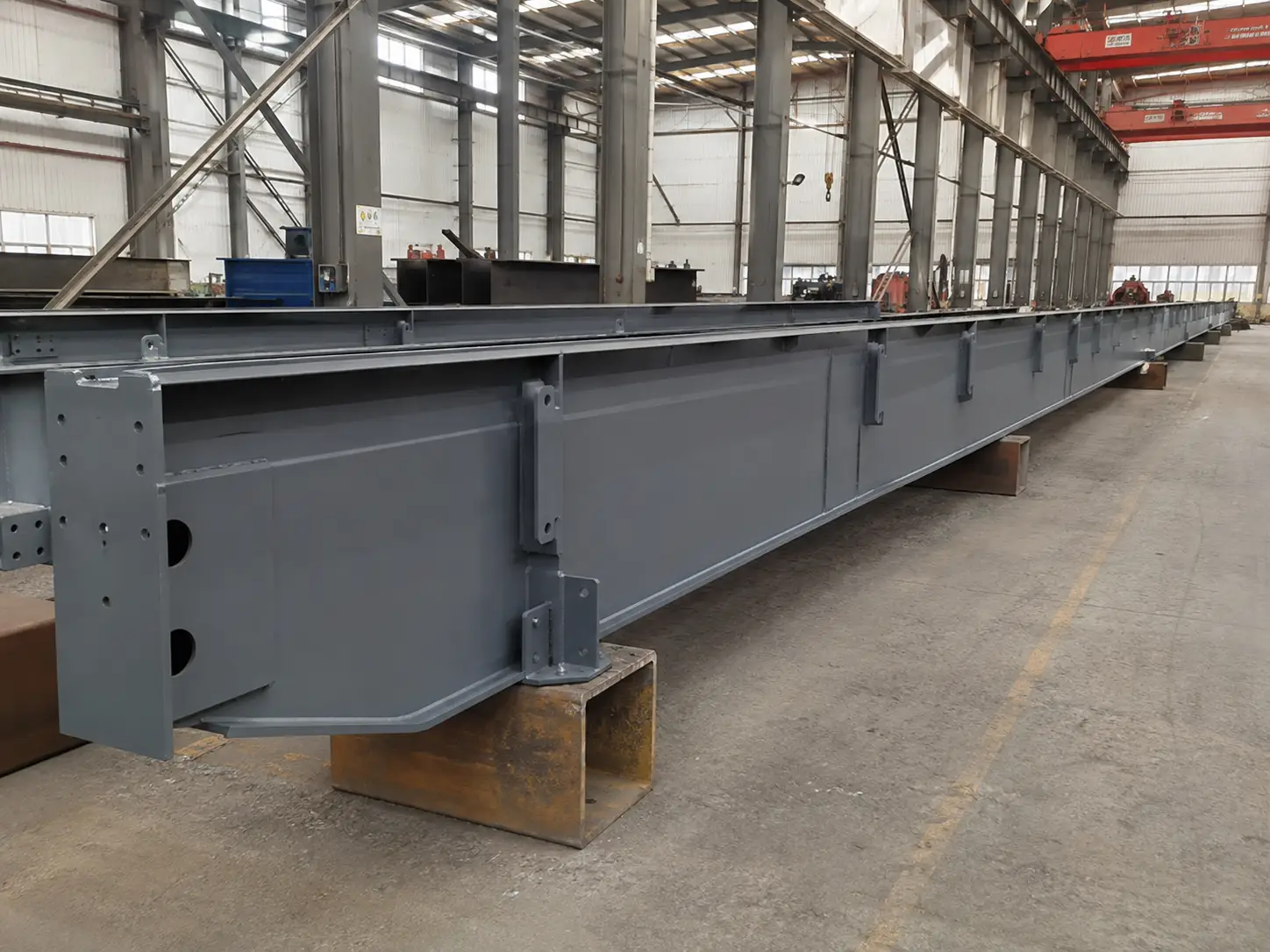Finished crane runway beam components with welded brackets and connection plates in steel fabrication factory