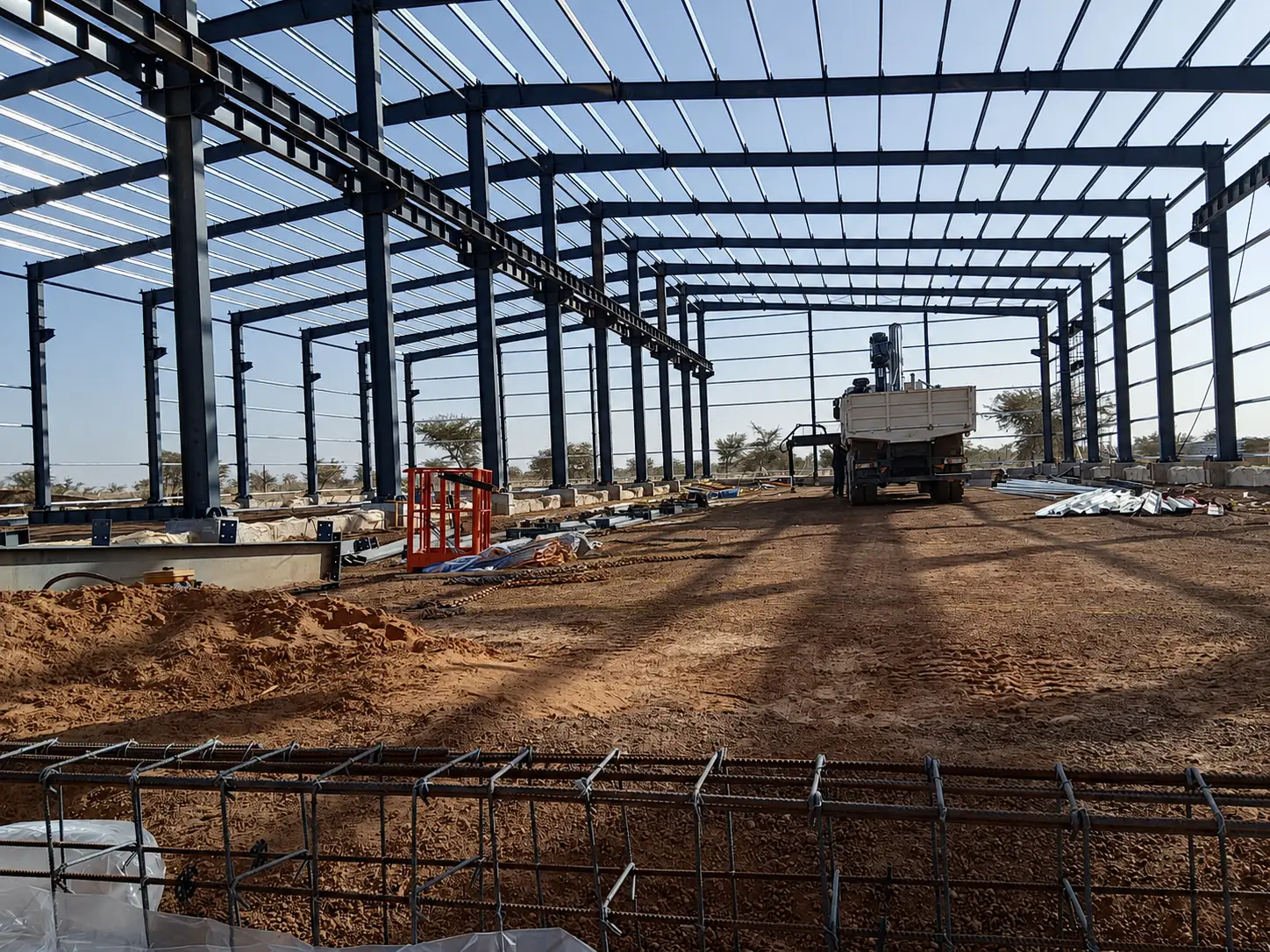 Welded H-section steel main frame installed for warehouse construction with roof purlins and crane runway beams