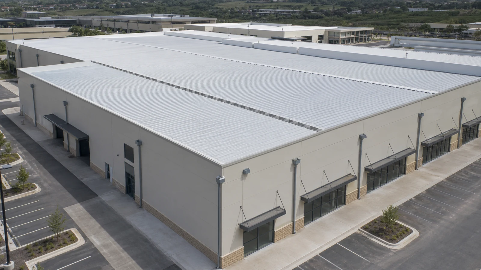 Completed steel shopping mall shows coordinated roof gutters, scuppers, and downpipes.